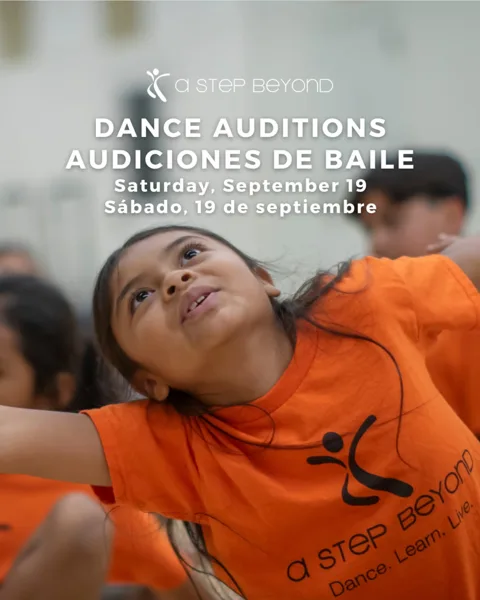 A young girl in an orange A Step Beyond t-shirt leans back mid-dance movement, with other children blurred in the background.