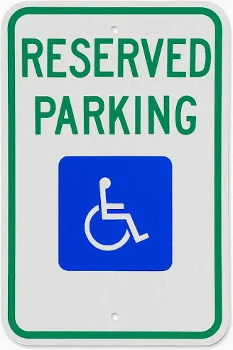 A white rectangular sign with green text reading "Reserved Parking" above the international blue wheelchair accessibility symbol.