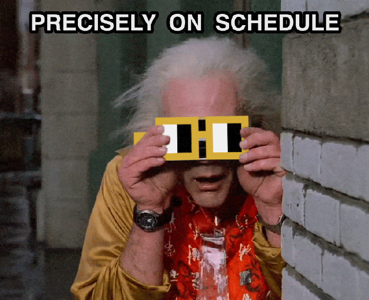 An elderly man with wild white hair holds a yellow film strip up to his eyes in an alleyway, wearing a gold jacket and red patterned shirt.