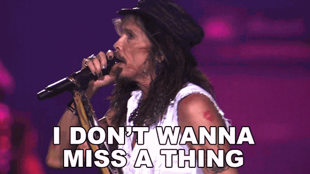A long-haired male rock vocalist performs on a concert stage while singing into a microphone, with the text "I Don't Wanna Miss A Thing" overlaid at the bottom.