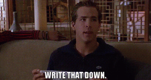 A young man in a navy polo shirt sits on a couch and speaks, with the caption "WRITE THAT DOWN" displayed at the bottom of the image.