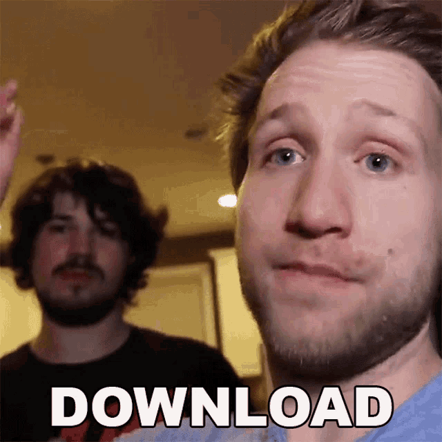 Two young men are indoors, with one facing the camera closely while the other stands in the background, and the word DOWNLOAD appears as text overlay at the bottom.