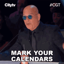 A bald man wearing sunglasses and a black suit sits at a judges table with the text "Mark Your Calendars" displayed below him on a Citytv broadcast of Canada's Got Talent.